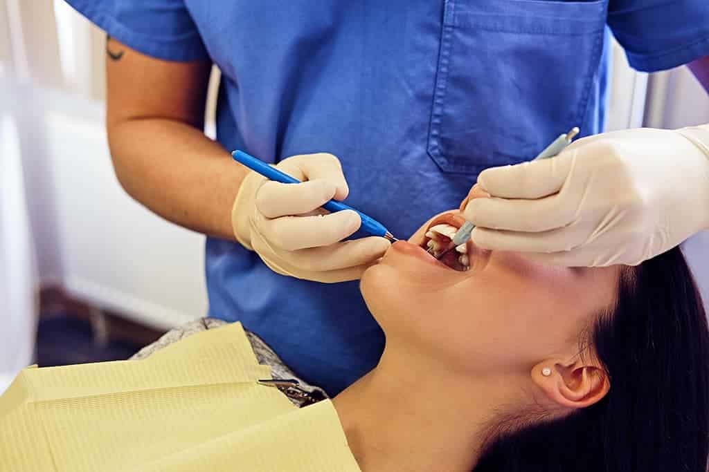 Dentist examining female's teeth in a dentistry