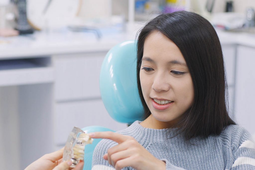 dentist showing a dental implant to patient