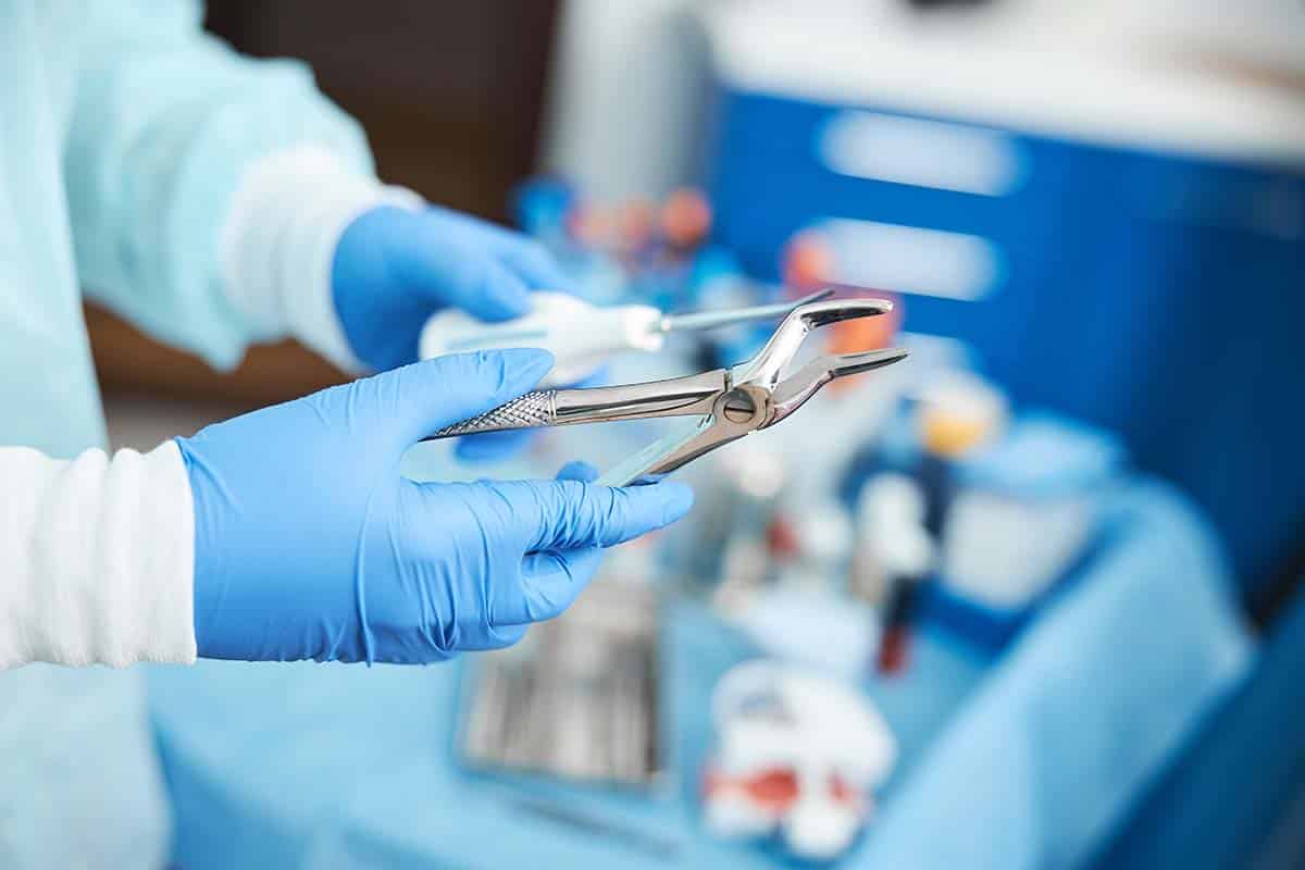 Dentist holding tooth extraction devices 