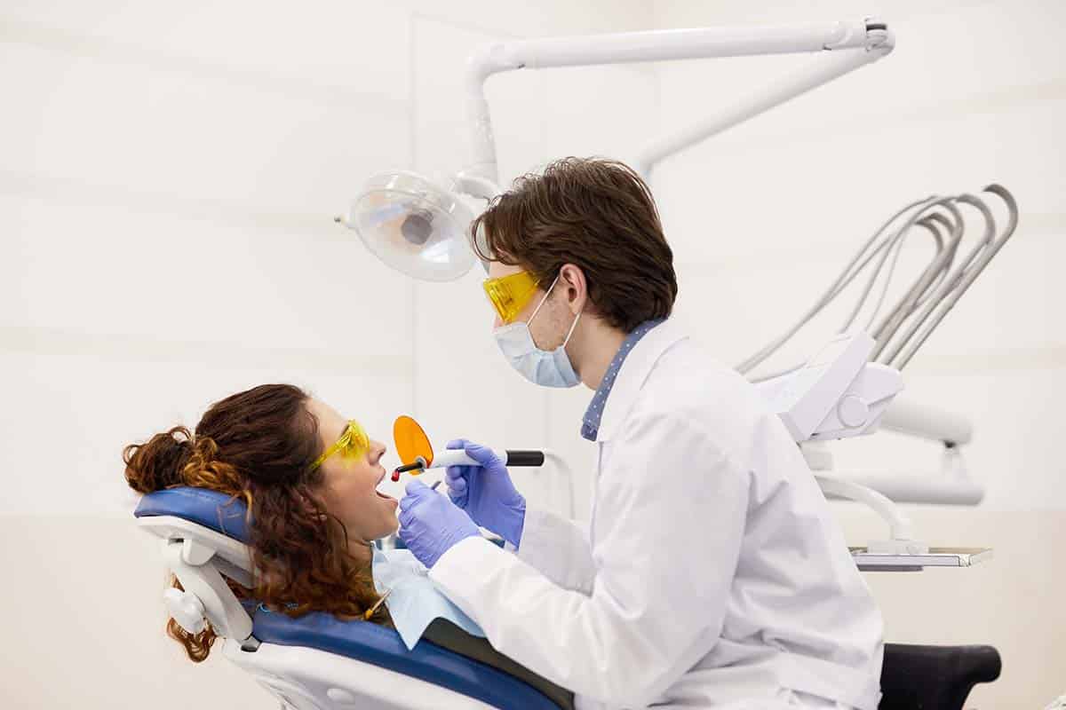 patient getting teeth whitening at dentist office