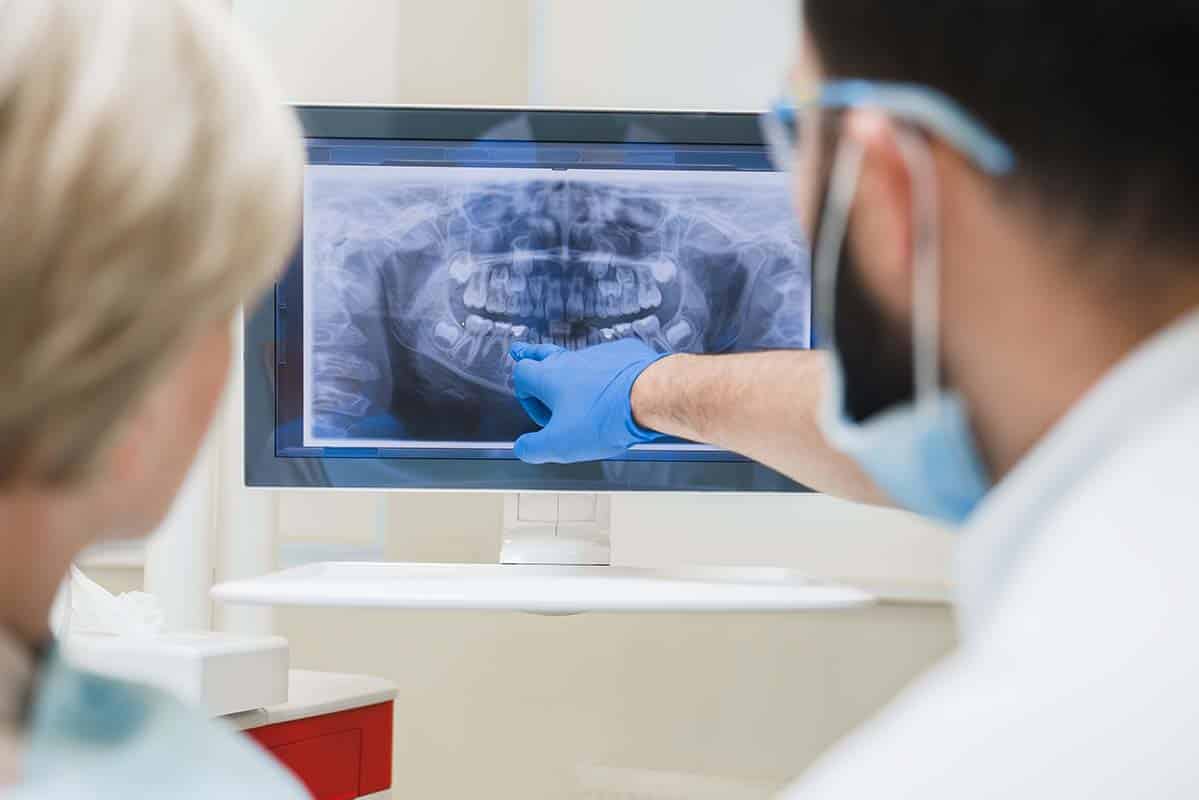 dentist explaining jaw bone loss to patient with an xray